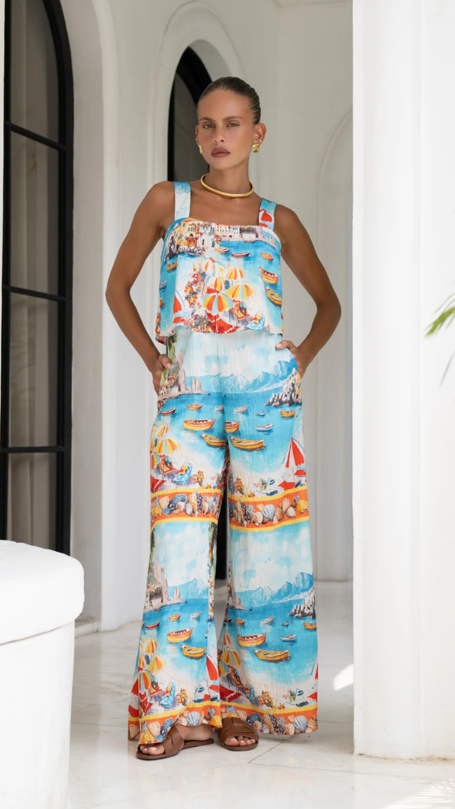 Model wearing the Kamali Jumpsuit – a sleeveless wide-leg jumpsuit with a vibrant coastal print and square neckline.