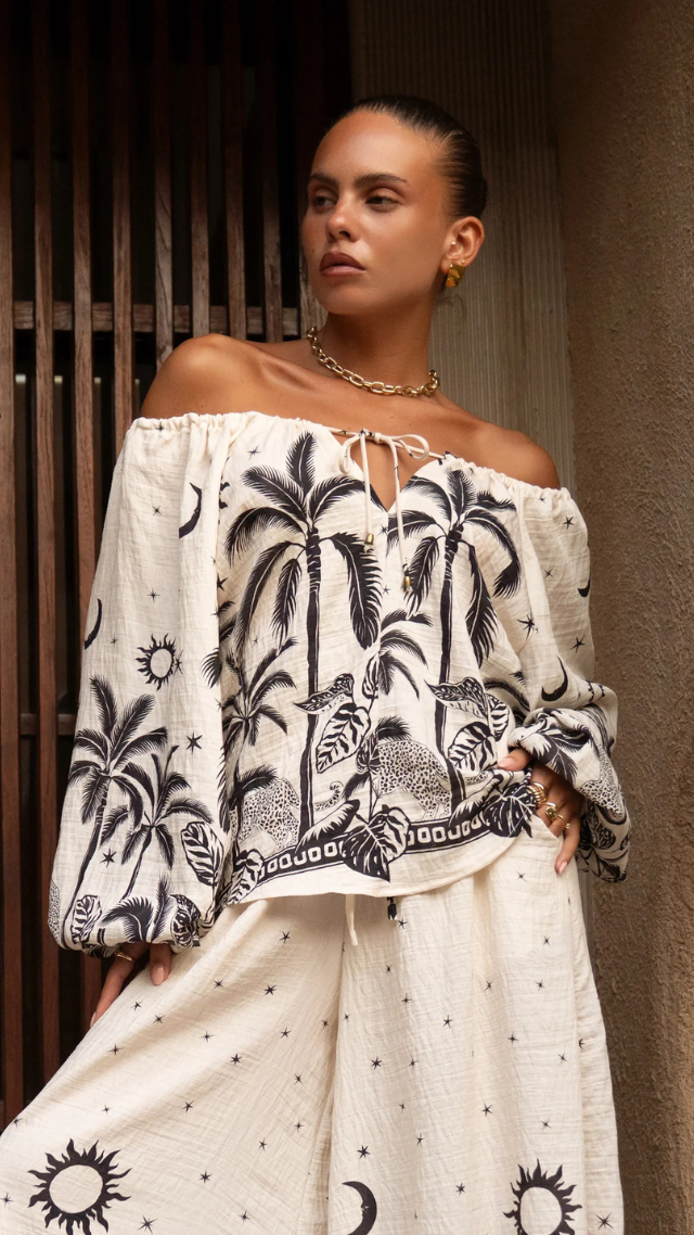 Model wears the Chandi Top in Sabor featuring a monochrome jungle print with long balloon sleeves, tie neckline, and relaxed fit.